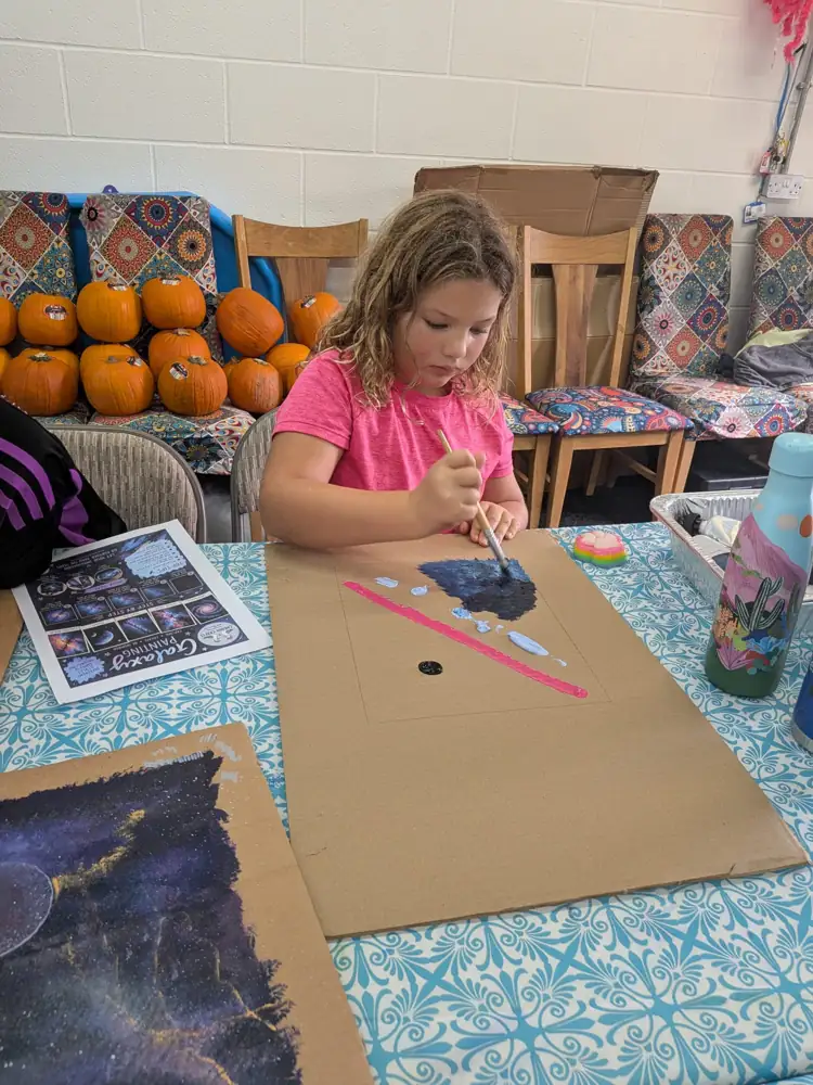 A child enjoying a creative activity at the craft table