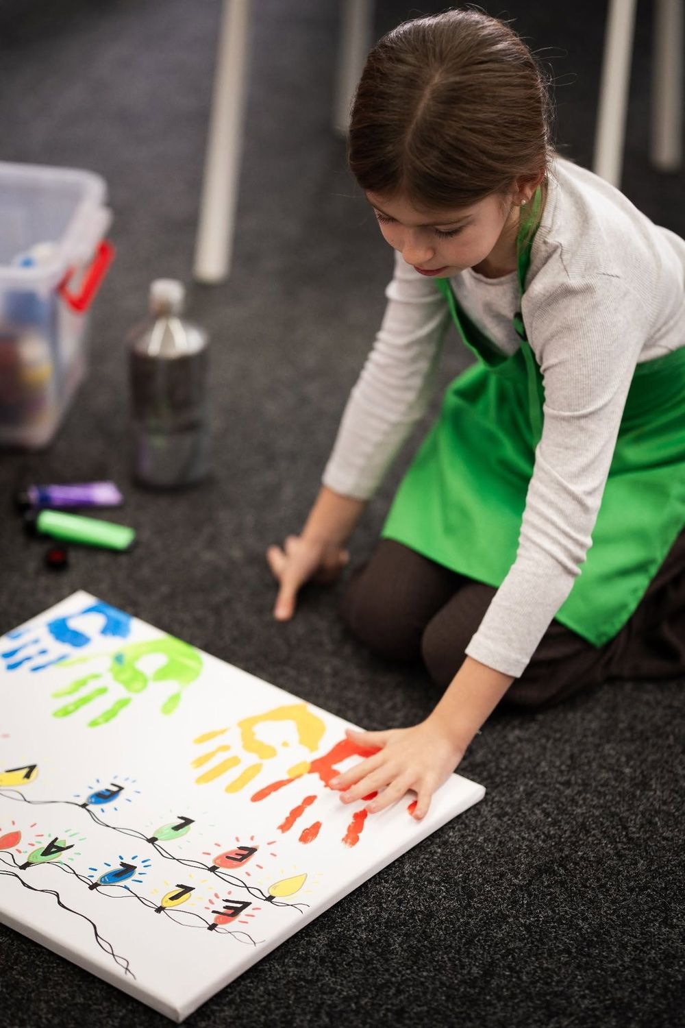 A child creating colourful handprint art at Cabana Crafts