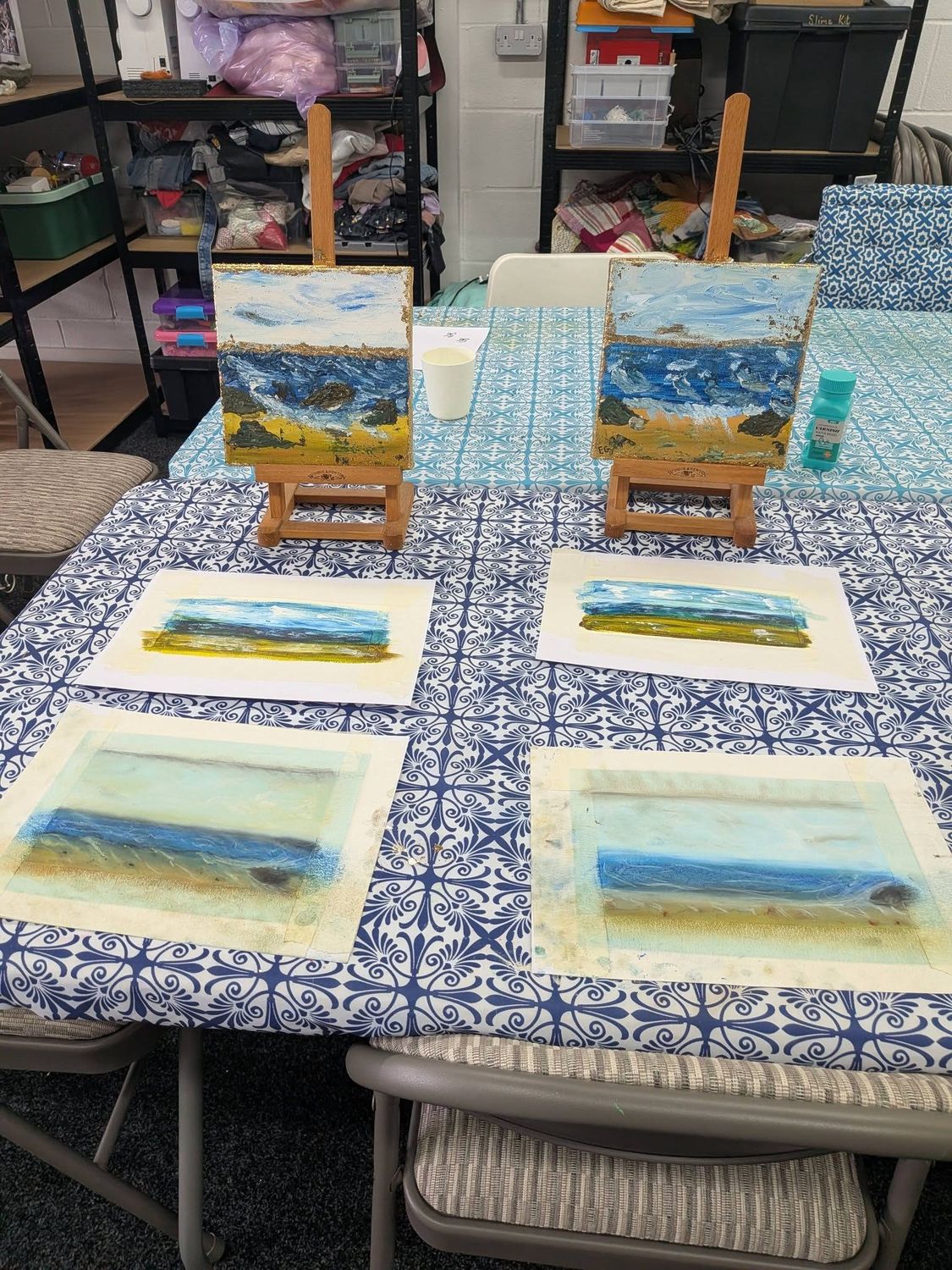 A seaside painting class set up with easels and canvases